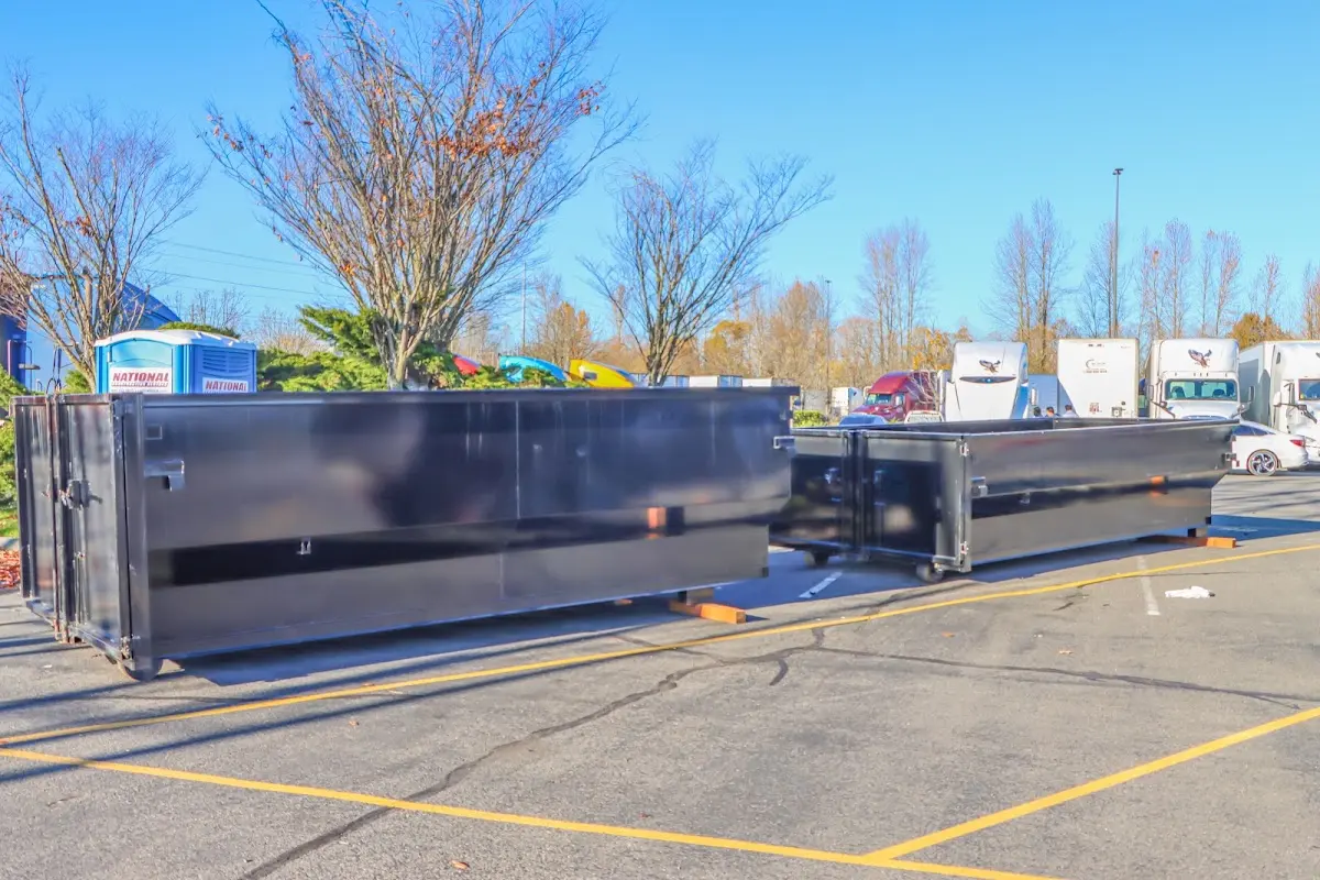 Professional dumpster rental service with roll-off container on residential driveway in Trumann